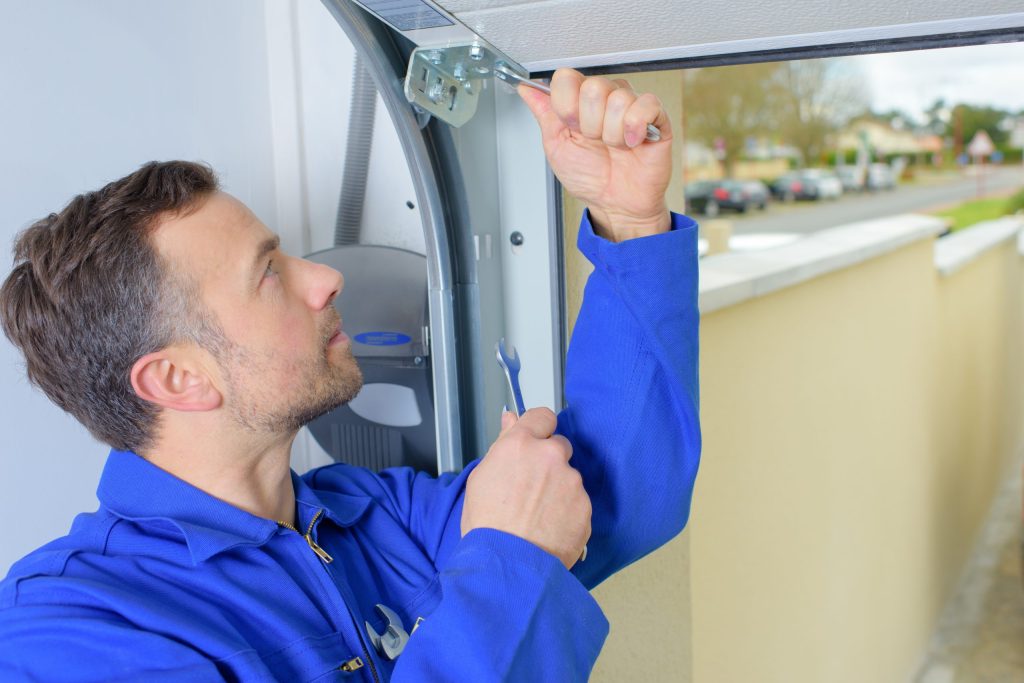 tech repairing garage door